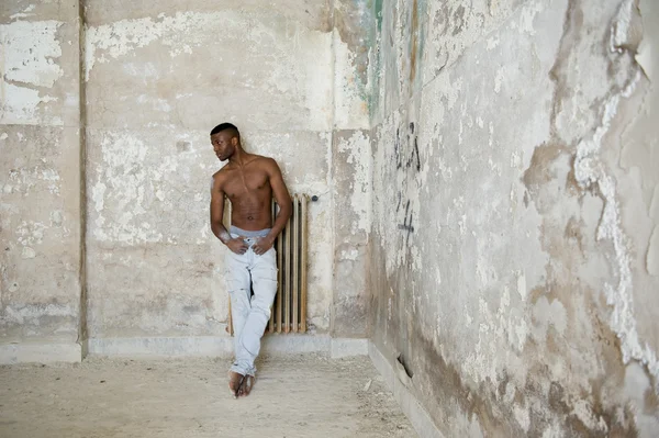 Hombre musculoso negro retrato intenso, interior. Dentro del edificio abandonado — Foto de Stock