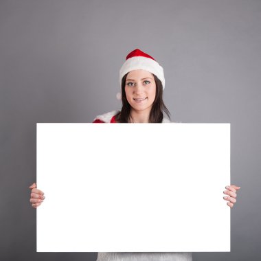 gri arka plan üzerinde izole billboard tutan santa şapka Noel kadın