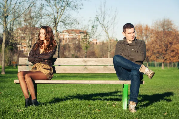 Wütendes junges Paar sitzt draußen auf einer Bank — Stockfoto