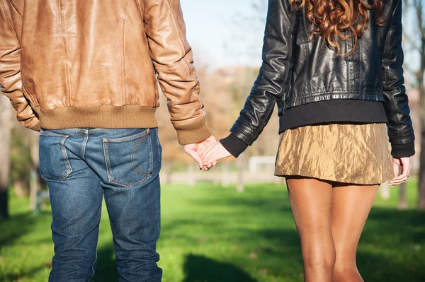 Hand i hand romantiska unga par promenader utomhus i höst park — Stockfoto