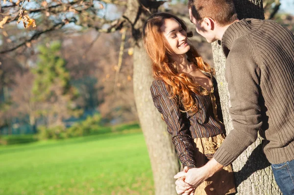 Romántica pareja joven jugando al aire libre en el parque de otoño —  Fotos de Stock