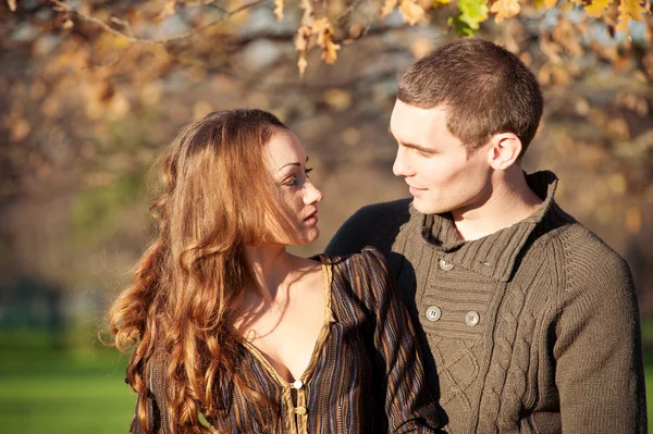 Pareja joven romántica mirándose al aire libre en el parque de otoño — Foto de Stock