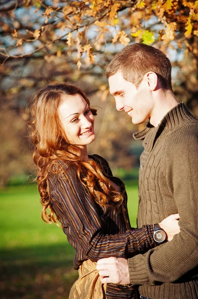 Romantic young couple playing outdoors in autumn park — Stock Photo, Image