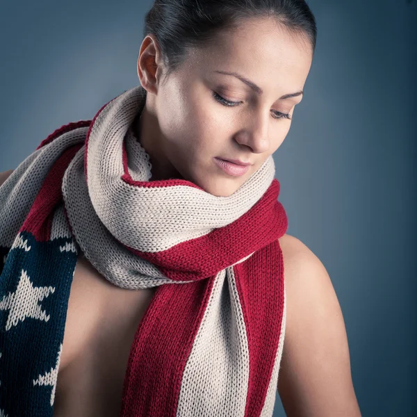 Retrato de mulher jovem com cachecol bandeira americana contra fundo cinza — Fotografia de Stock