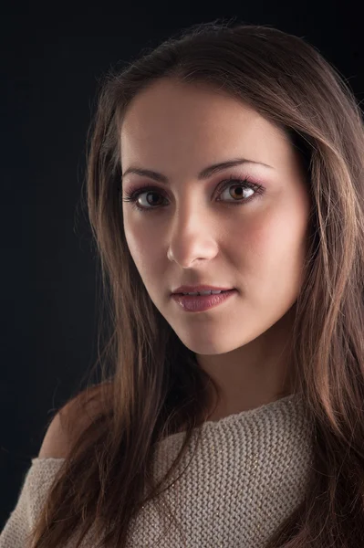 Young woman close up portrait against dark background — Stock Photo, Image