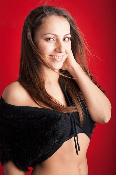 Lachende brunette vrouw dicht omhoog portret tegen rode achtergrond — Stockfoto