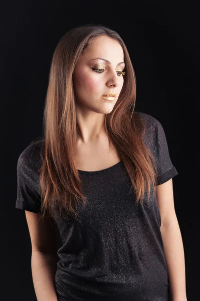 Young woman with golden make up portrait against dark background — Stock Photo, Image