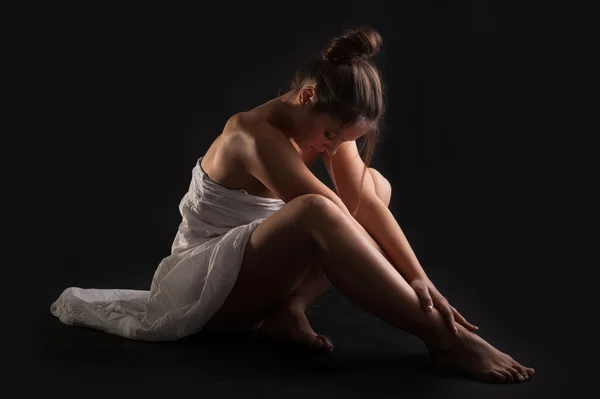 Intimate woman portrait wearing white dress against dark background — Stock Photo, Image