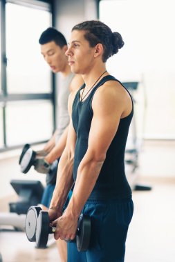 iki genç erkek spor salonunda dumbbells ile egzersiz