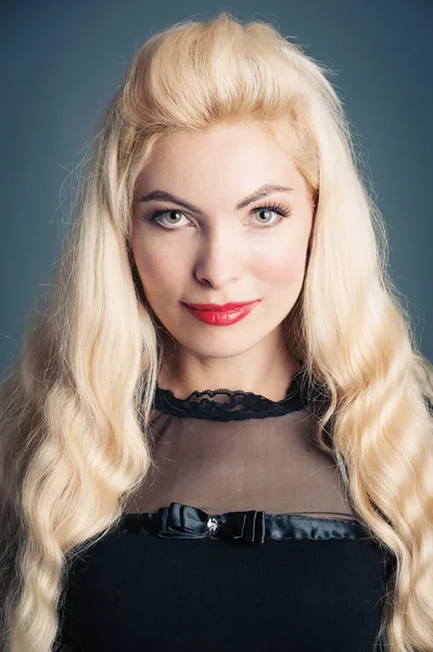 Beautiful blonde woman close up portrait against dark background — Stock Photo, Image