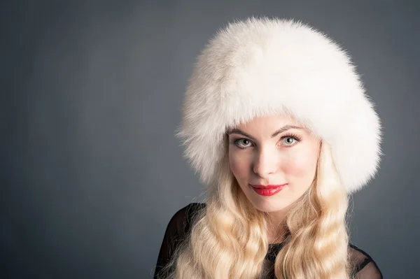 Elegante blonde vrouw met witte berenmuts — Stockfoto