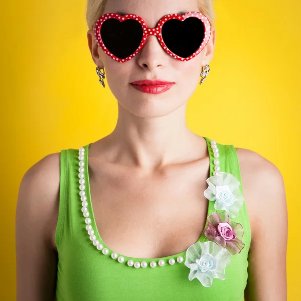 Ξανθό κορίτσι με τα γυαλιά καρδιά κίτρινο φόντο — Φωτογραφία Αρχείου