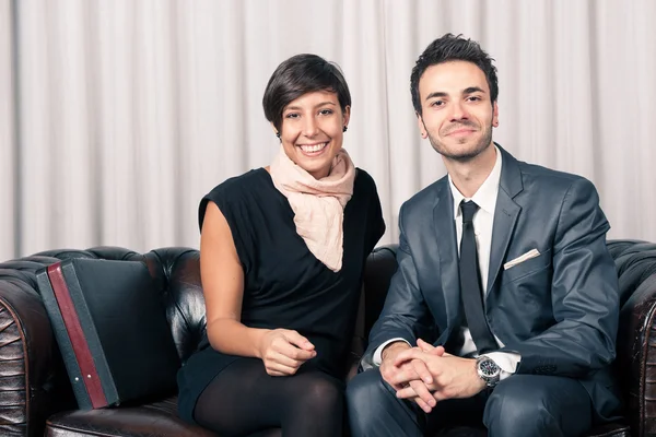 Paar aus Geschäftsmann und Frau entspannt sich auf einem Sofa in Hotellobby — Stockfoto