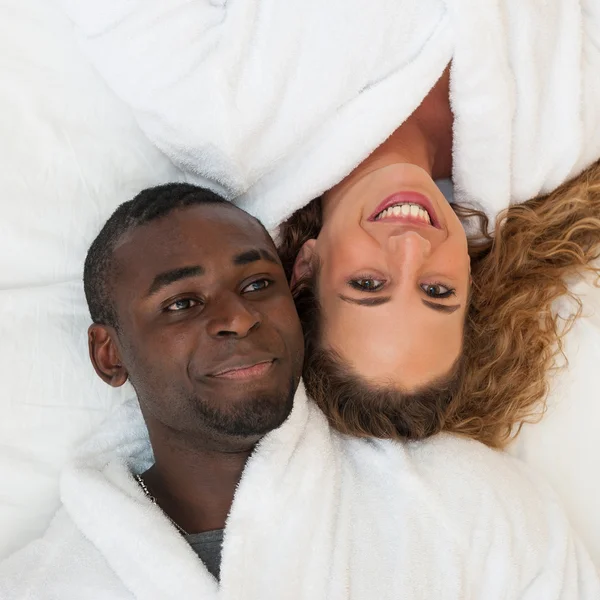 Happy young couple lying in bed, top view — Stock Photo, Image