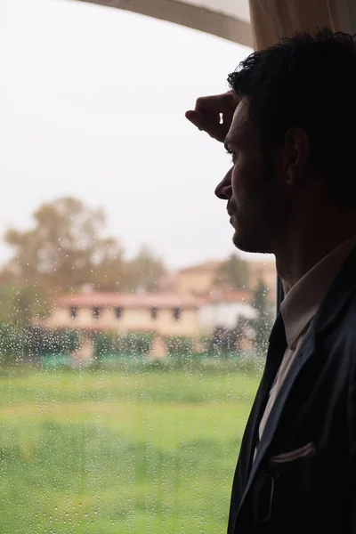 Young man alone at the window — Stock Photo, Image