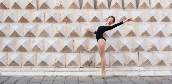 Unga vackra ballerina dansa utomhus framför palazzo dei diamanti i ferrara, Italien — Stockfoto