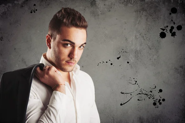 Young man close up portrait against dark grunge background — Stock Photo, Image