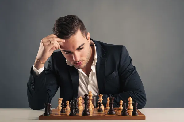 Homme jouant aux échecs, isolé sur fond sombre — Photo