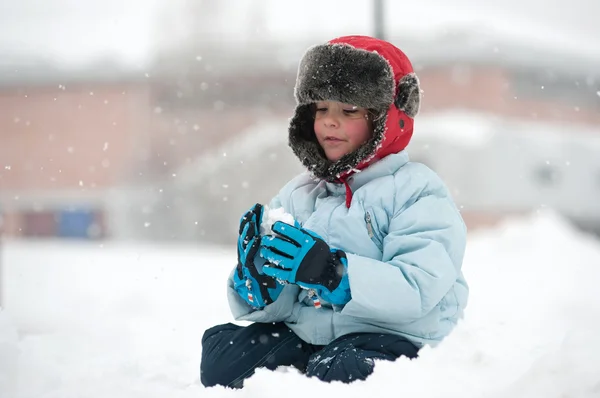 Porträt eines kleinen Kindes, das im Schnee spielt — Stockfoto