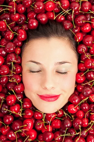 Jovem menina sorrindo retrato com os olhos fechados cercado por cerejas — Fotografia de Stock