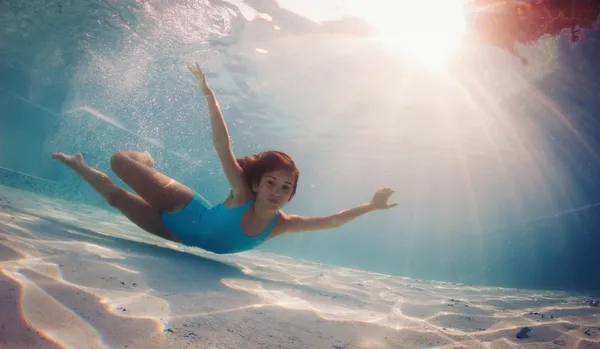 Retrato de niña bajo el agua en la piscina —  Fotos de Stock