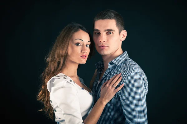 Attractive young couple. Studio portrait on dark background — Stock Photo, Image