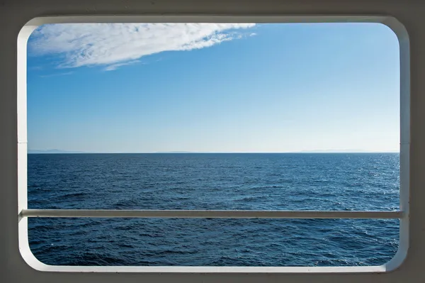 Schip windows met een ontspannende zeegezicht en blauwe lucht uitzicht — Stockfoto