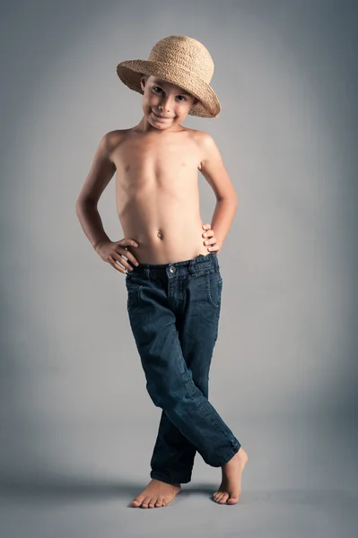 Young boy with straw hat. Studio portrait with grey background Stock Photo