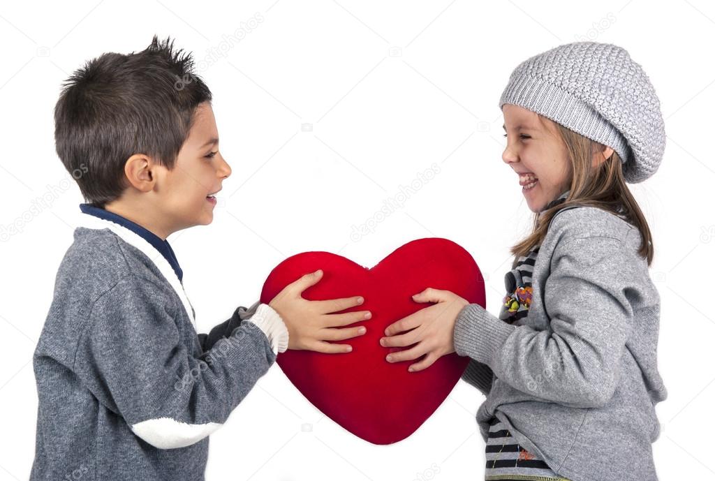 Couple of kids playing with red heart over white background. Valentines