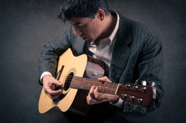 adam gitar çalmaya karanlık grunge arka planı.