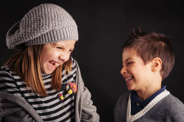 Couple of kids laughing on black background. — Stock Photo, Image
