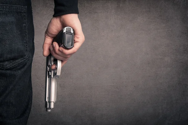 Killer with gun close up over grunge background with copyspace. — Stock Photo, Image