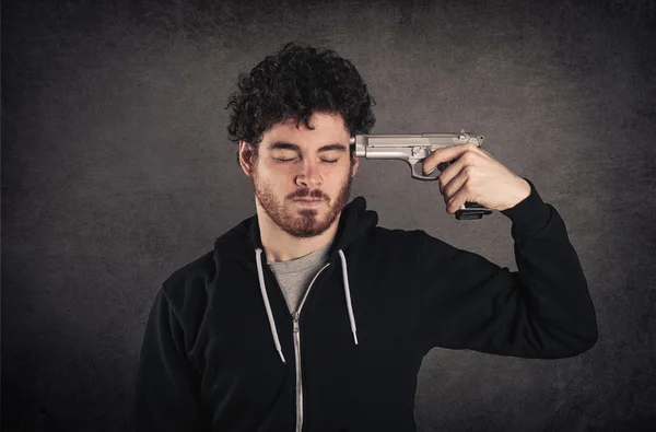 Joven suicida con arma sobre fondo grunge oscuro . —  Fotos de Stock