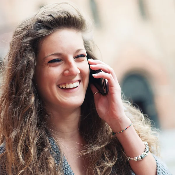 Adolescente riendo en el teléfono móvil en la plaza de San Esteban, Bolonia, Italia . — Foto de Stock