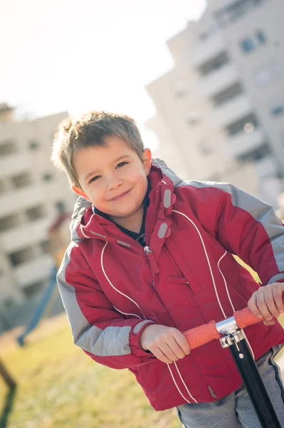 스쿠터를 타고 야외에서 초상화를 그리는 행복 한 소년. — 스톡 사진