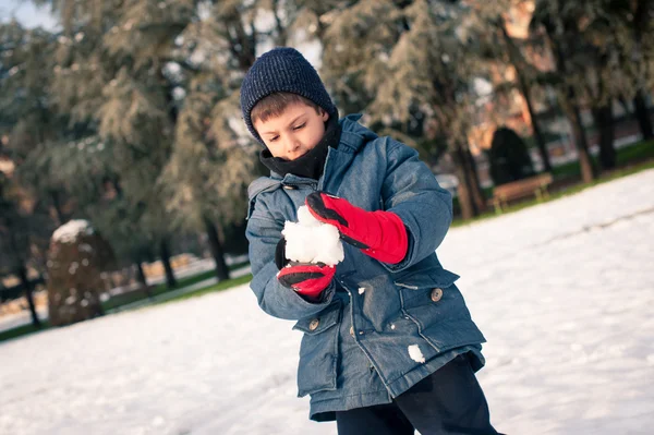 Bambino che si diverte sulla neve con la palla di neve. — Foto Stock