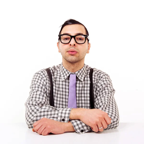 Lustiges Porträt eines jungen Nerds mit Brille am Schreibtisch isoliert auf weißem Hintergrund. — Stockfoto