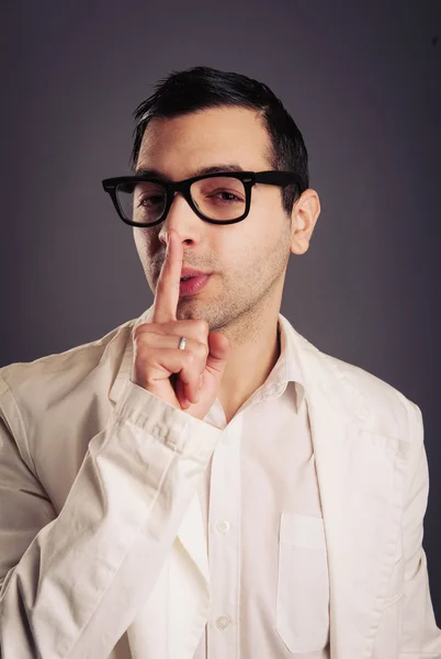 Grappige portret van jonge nerd met bril op grijze achtergrond. — Stockfoto