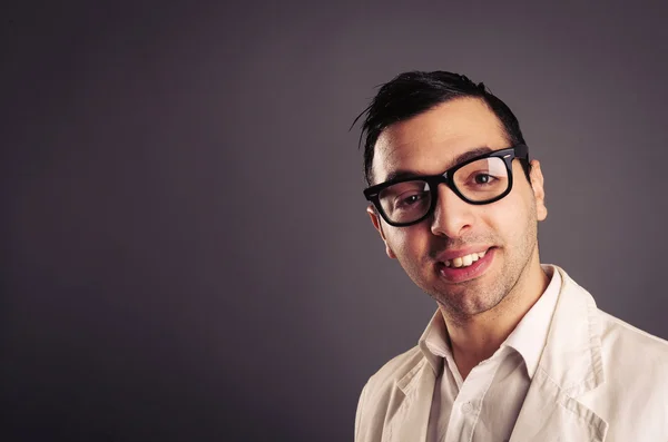 Lustiges Porträt eines jungen Nerds mit Brille auf grauem Hintergrund. — Stockfoto