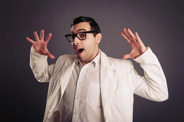 Drôle de portrait de jeune nerd avec des lunettes sur fond gris . — Photo