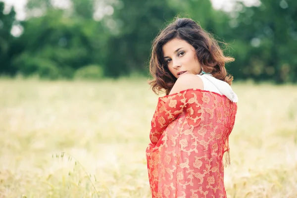 Portrait of charming young girl with red fabric. — Stock Photo, Image