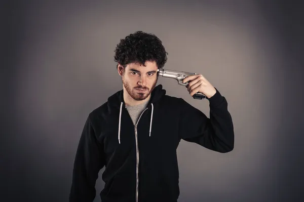 Ung man självmord med pistol över mörk bakgrund. — Stockfoto