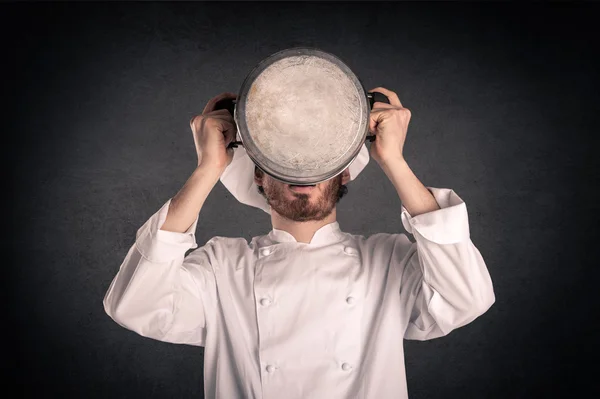 Young cook man with uniform drinking from pot over grunge background. — Stock Photo, Image