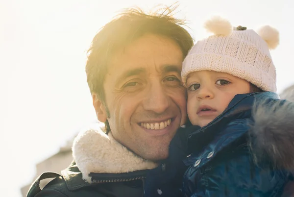 Porträt von Vater und kleiner Tochter im Freien im Park. Gegenlicht Sonne. — Stockfoto