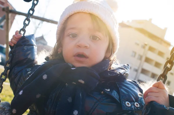 Little smiling girl swinging close up portrait. Back light sun. — Stock Photo, Image