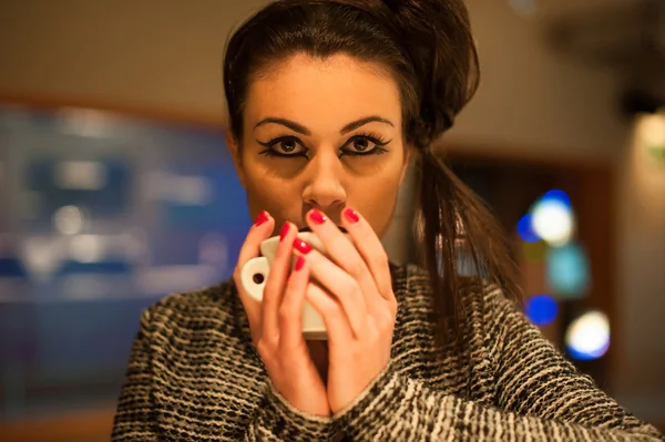 Elegant woman drinking coffee in a bar. Night time. — Stock Photo, Image