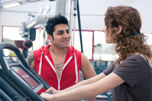 Pareja hablando en el gimnasio mientras entrena . — Foto de Stock