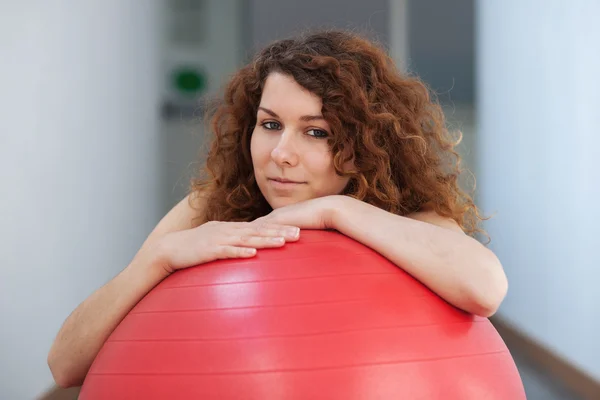 Mladá žena s červenou kouli portrét v tělocvičně. — Stock fotografie