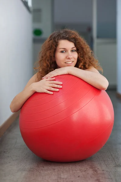 Ritratto di giovane donna con palla rossa in palestra . — Foto Stock