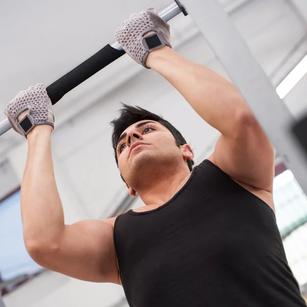 Jeune homme s'entraînant dans la salle de gym. — Photo